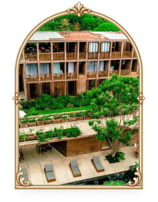 Hotel pequeño con alberca rodeado de jardines